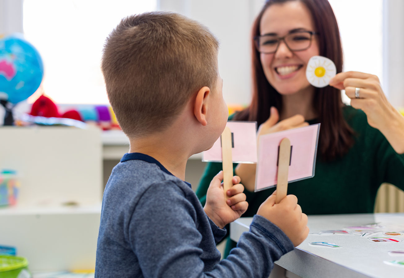 Preschooler practicing correct pronunciation with a female speech therapist